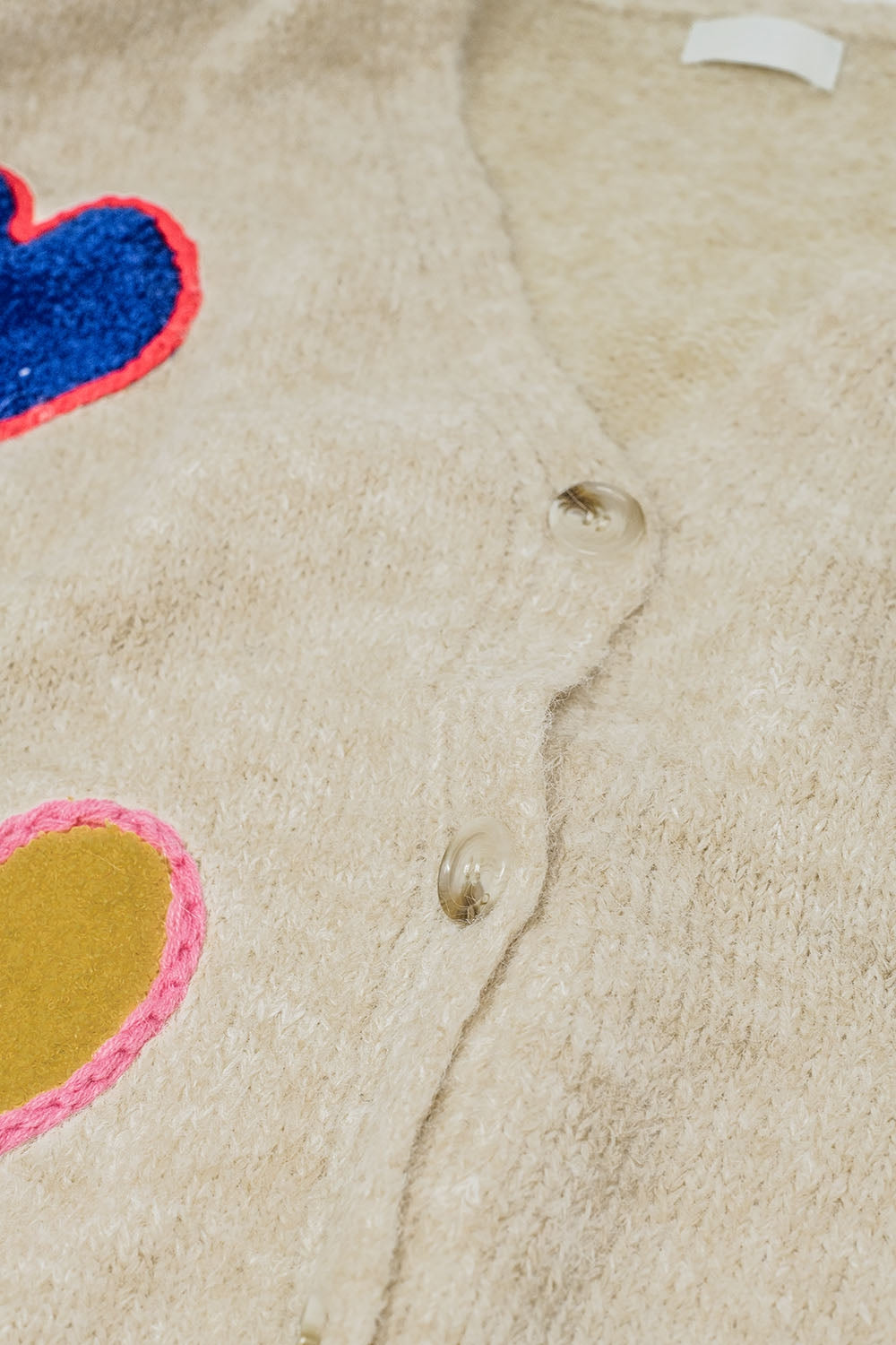 Beige knitted cardigan with embroidered hearts