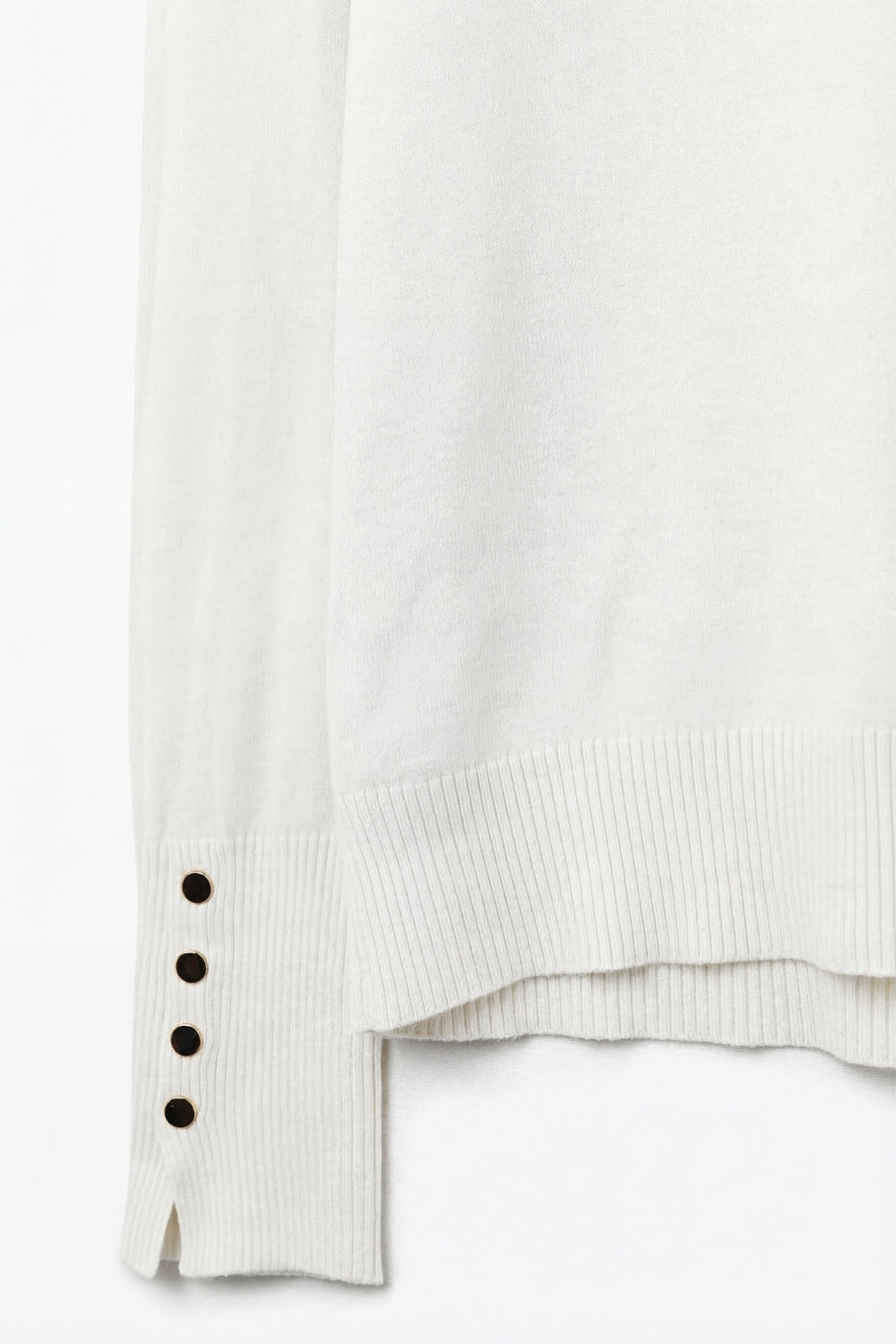 White turtleneck sweater with gold buttons on the cuff