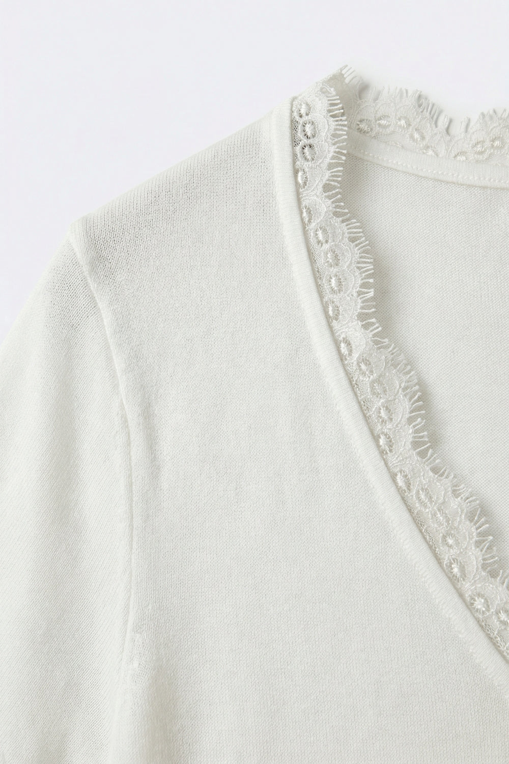 Fine and soft knit sweater with V-neck and lace trim in white