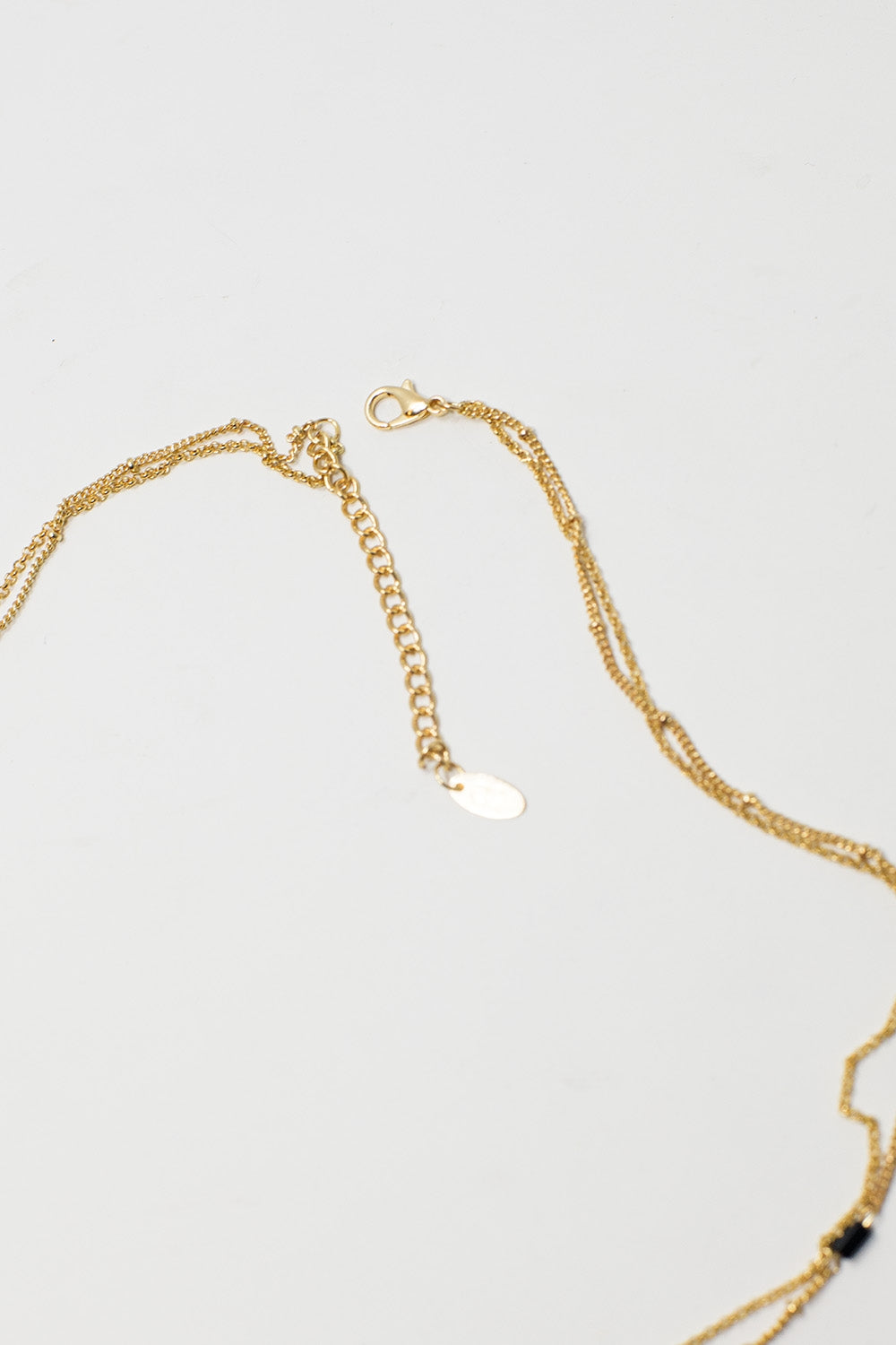 Short 2 in 1 Gold Necklace with Black Beads and White Marbled Stone.
