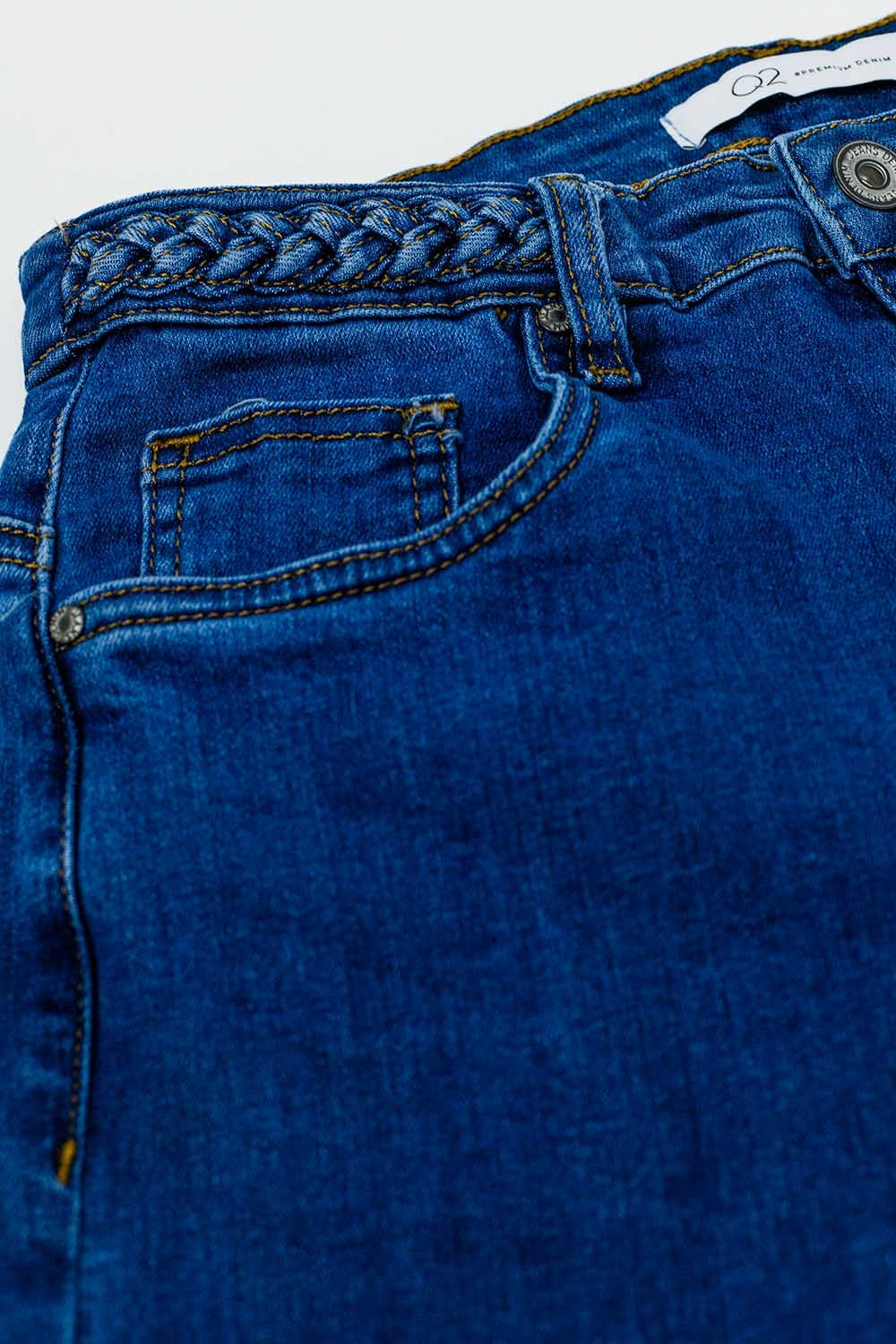 Jean basique en denim bleu foncé, avec détail tressé à la taille