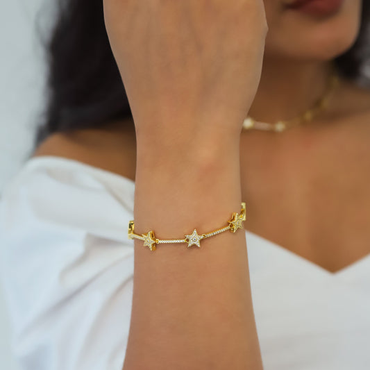 Luna Charles gold plated bracelet with star charms, elegantly worn on a wrist