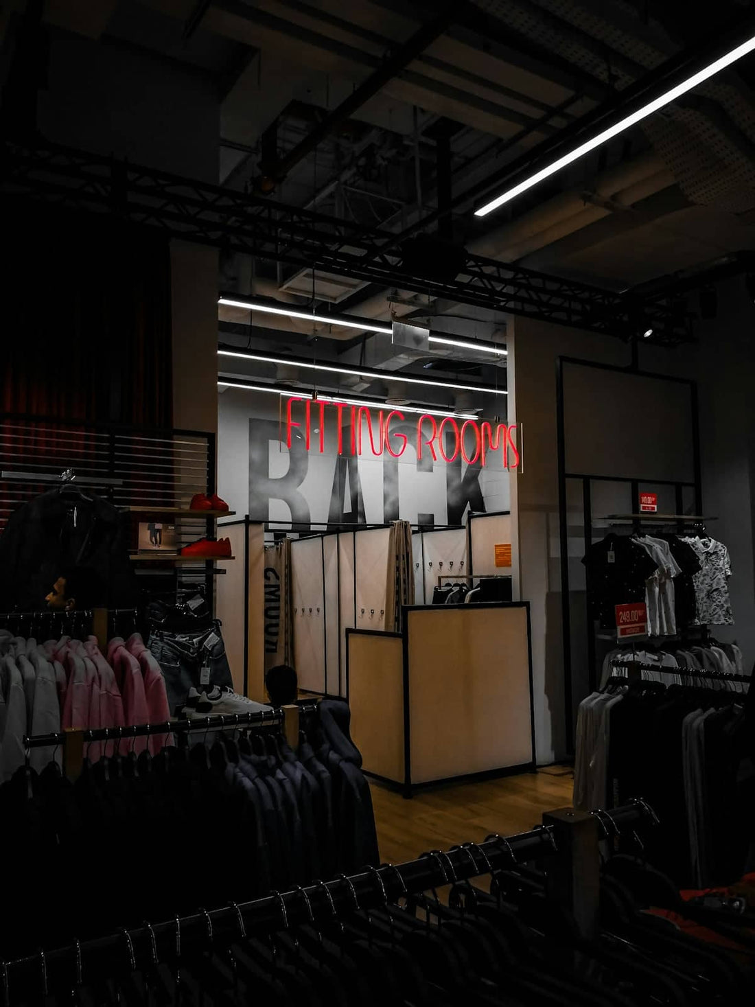 a clothing store with a neon sign above it