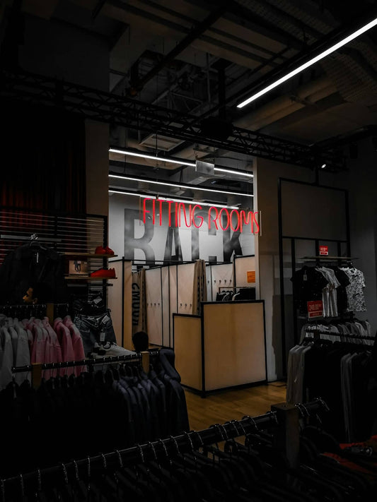 a clothing store with a neon sign above it