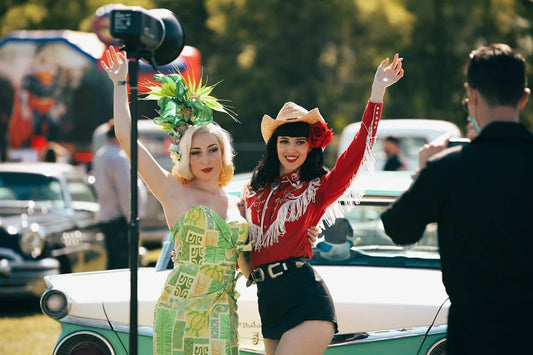 woman in red long sleeve shirt and black shorts holding black and red camera