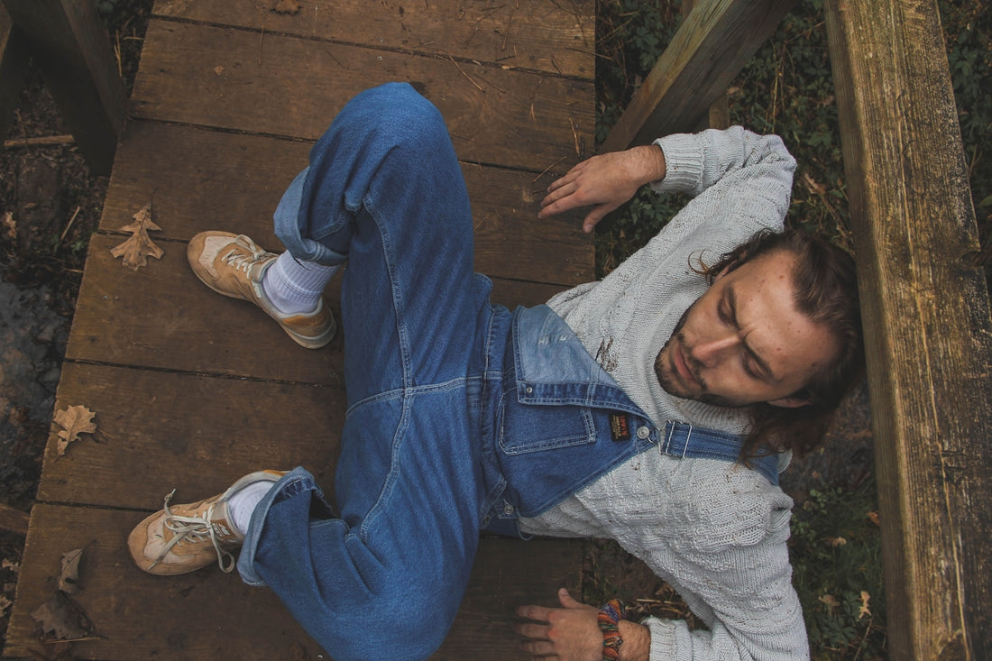a man laying down on a wooden walkway