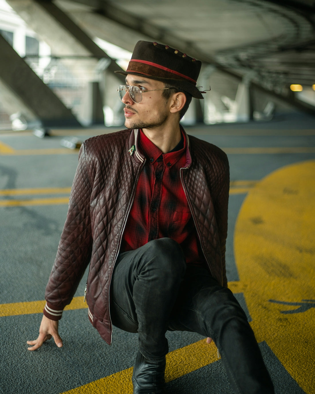 a man with a hat and glasses sitting on the ground