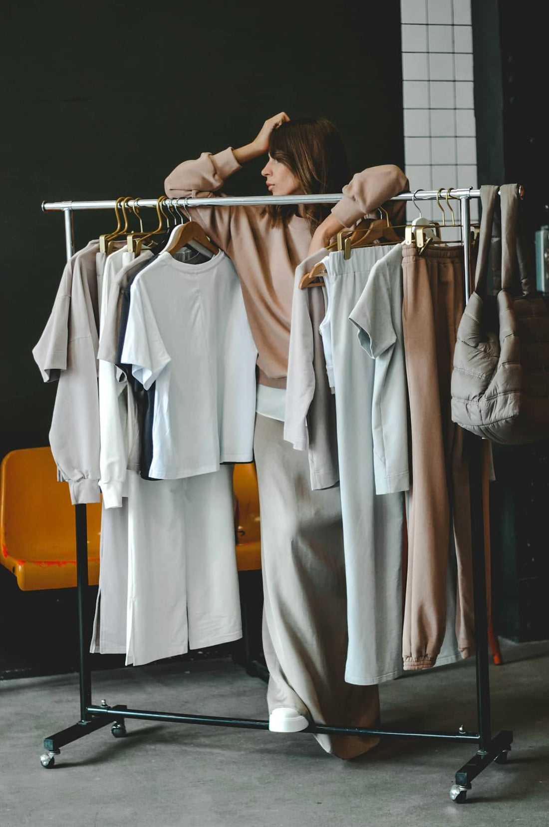 Woman browses clothes on a rack, choosing an outfit.