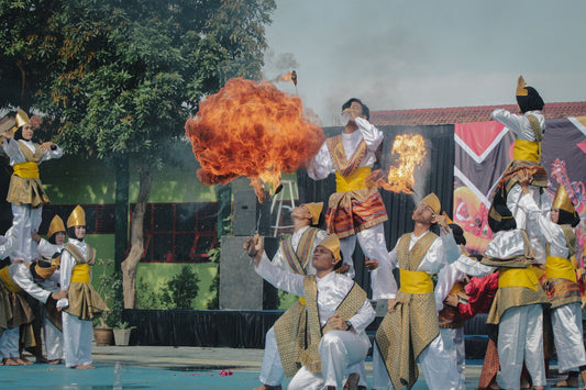 Performers in traditional attire during a fiery show.