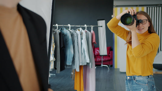 Photographer takes picture of model in studio.