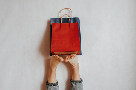 Two shopping bags held between feet