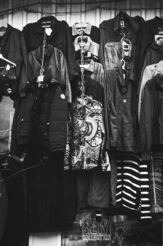 Assortment of jackets and shirts hanging on a rack.