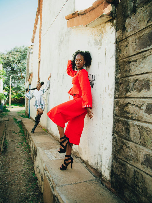 Two fashionable women posing in an urban alley.