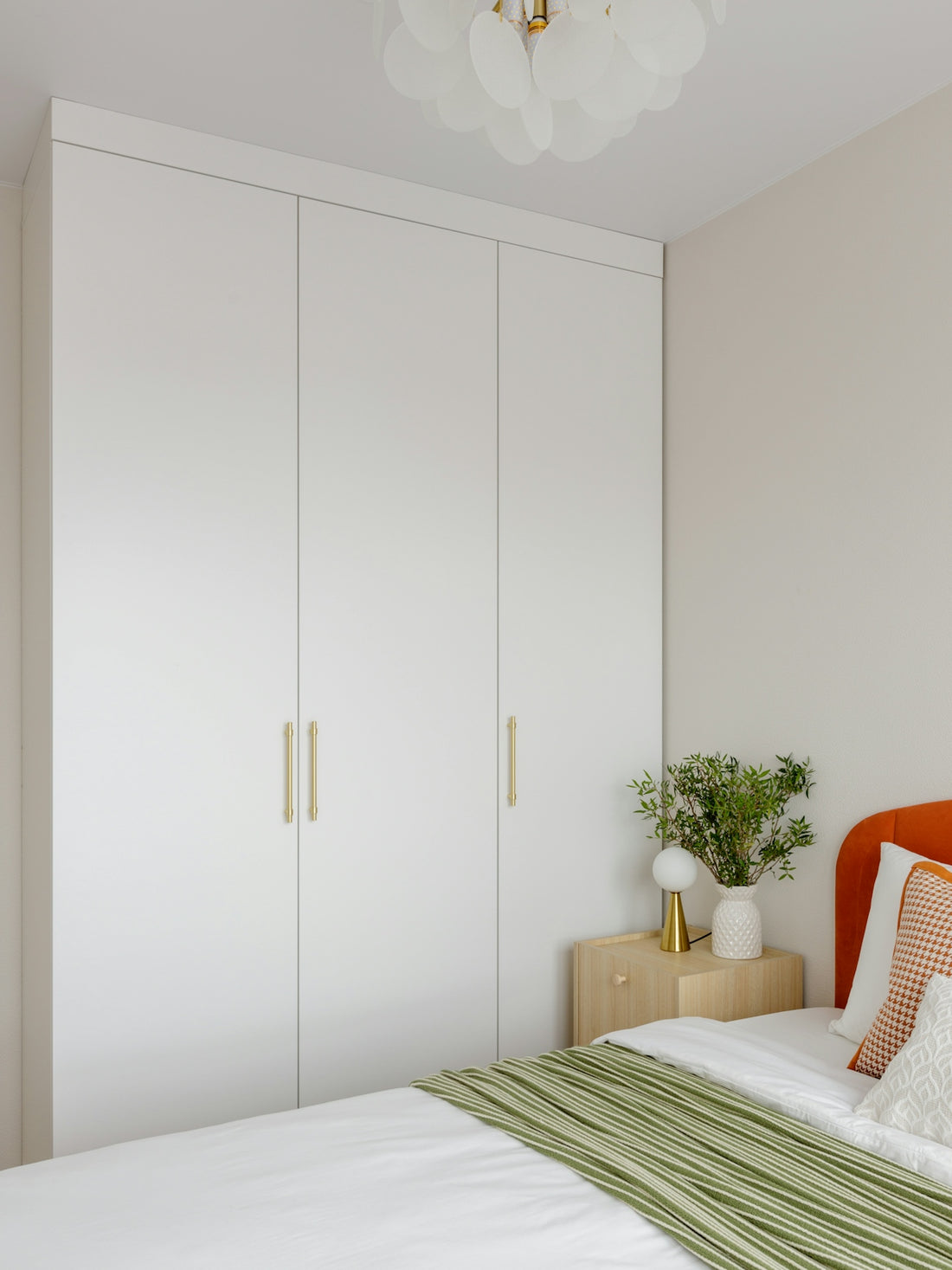 Modern bedroom with white built-in wardrobe and bed