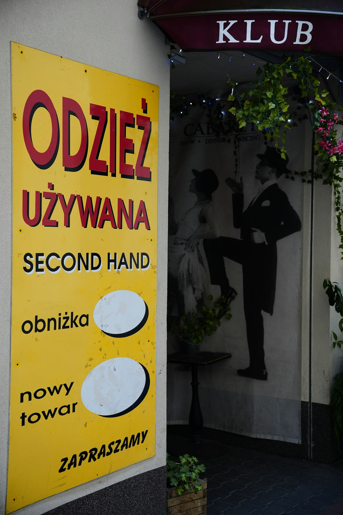 Yellow second hand sign next to a club entrance.