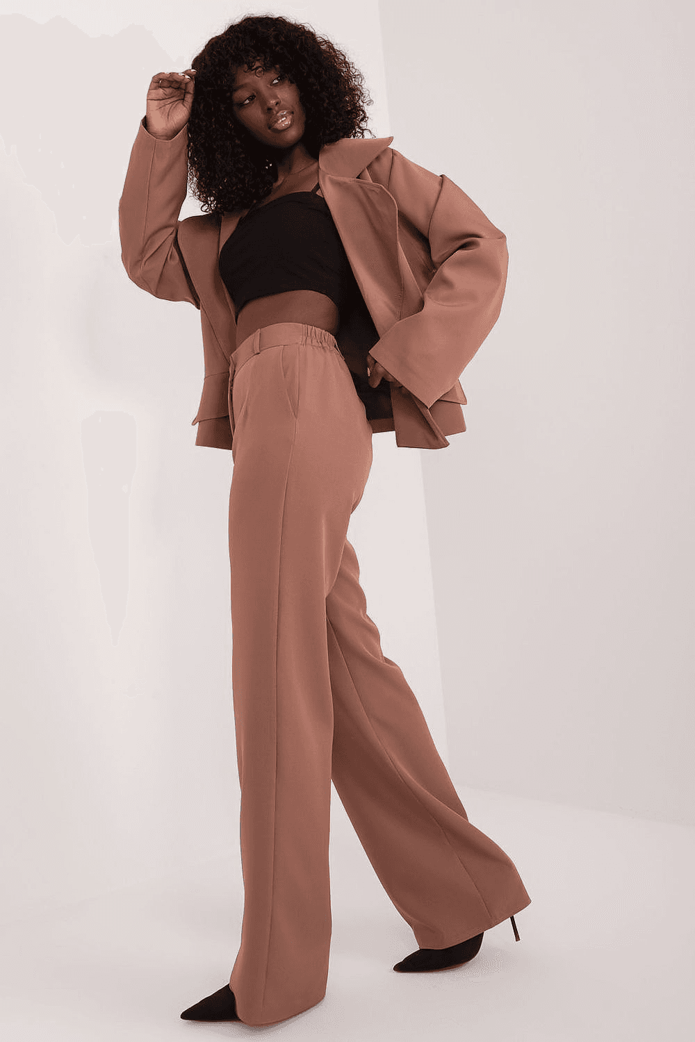 Stylish women's outfits UK featuring a chic brown tailored suit with wide-leg trousers and black crop top
