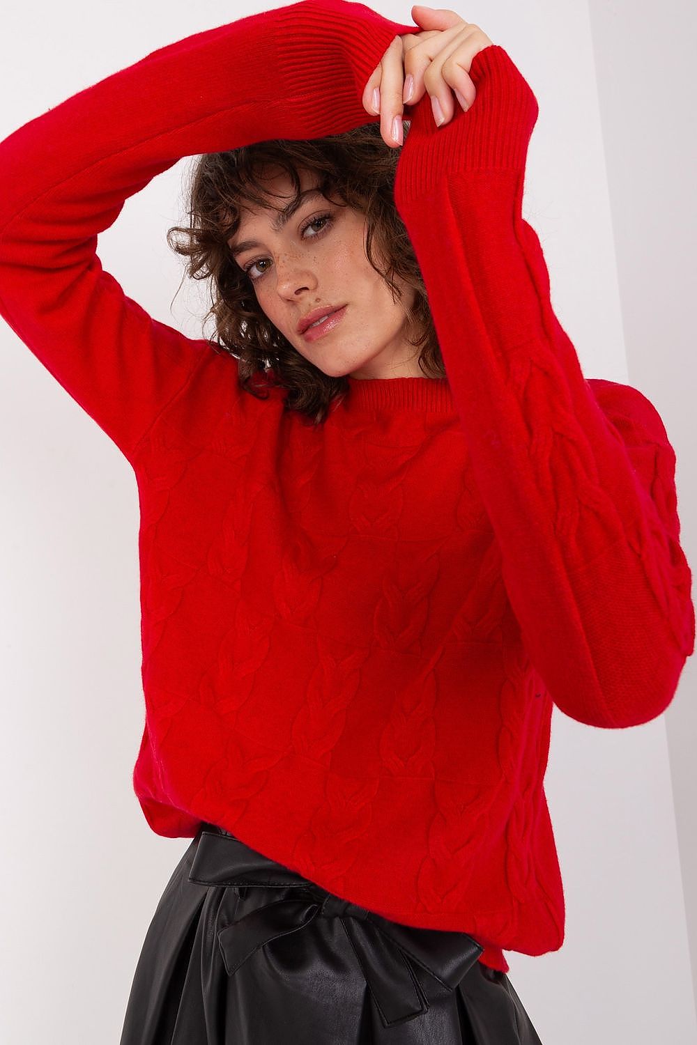 Woman wearing fashionable jumpers and cardigans with leopard print jumper over bright pink shirt and black trousers