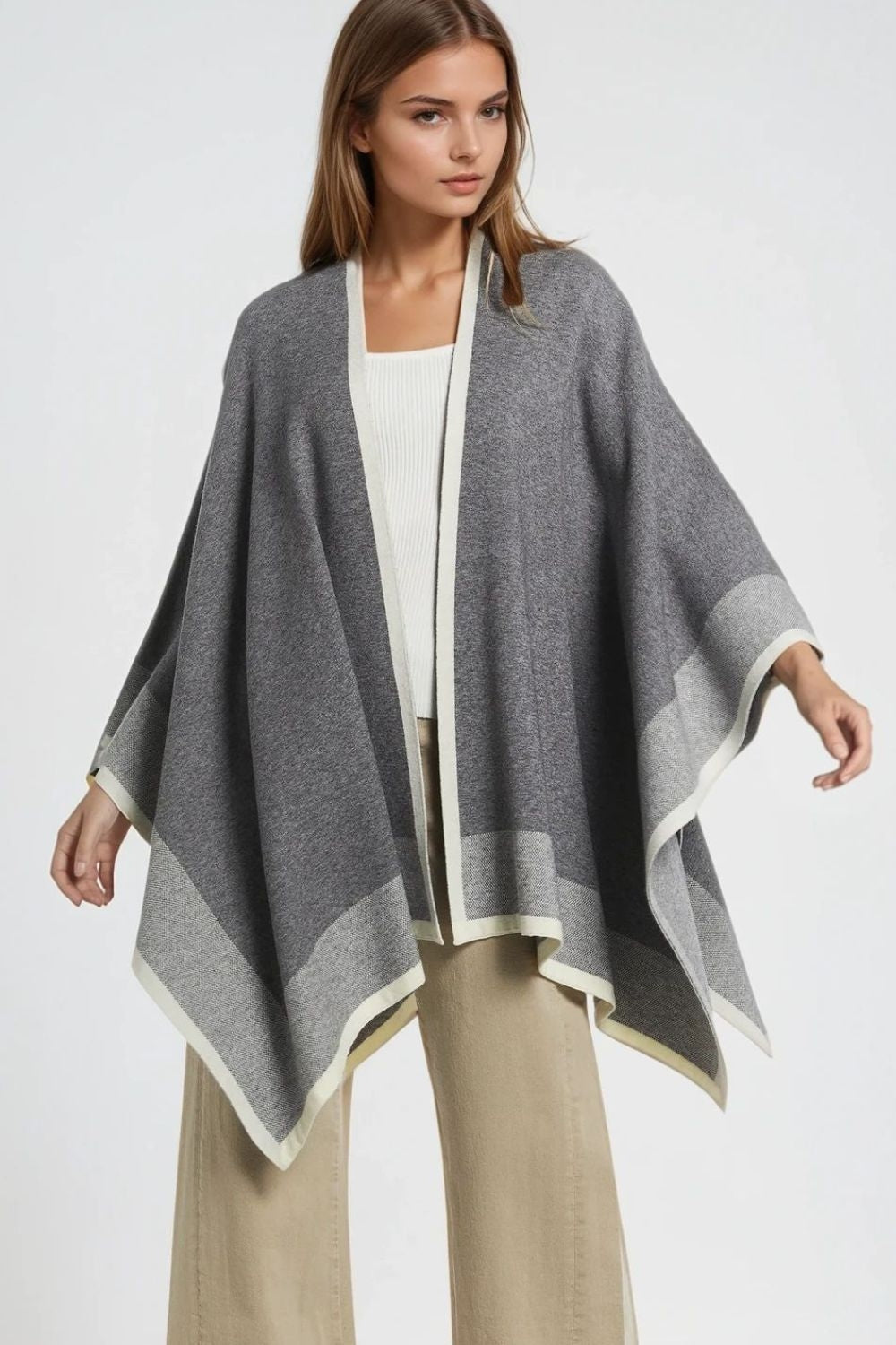 Knitted poncho in grey with ecru trim