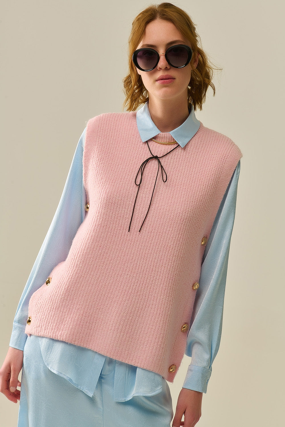 Pink sleeveless sweater with gold buttons