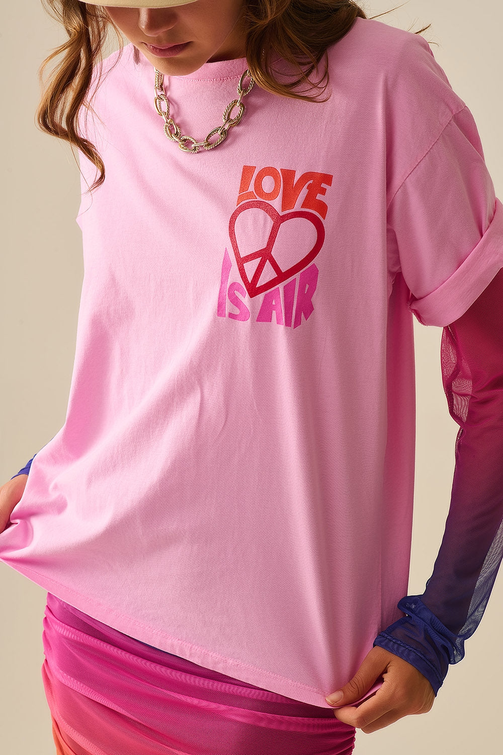 T-shirt rose avec « Love is Air » et logo cœur avec « Peace »