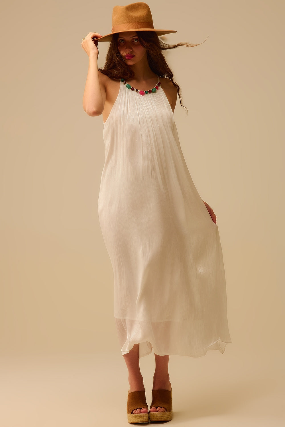 Robe longue plissée blanche à col montant, avec décolleté orné de perles