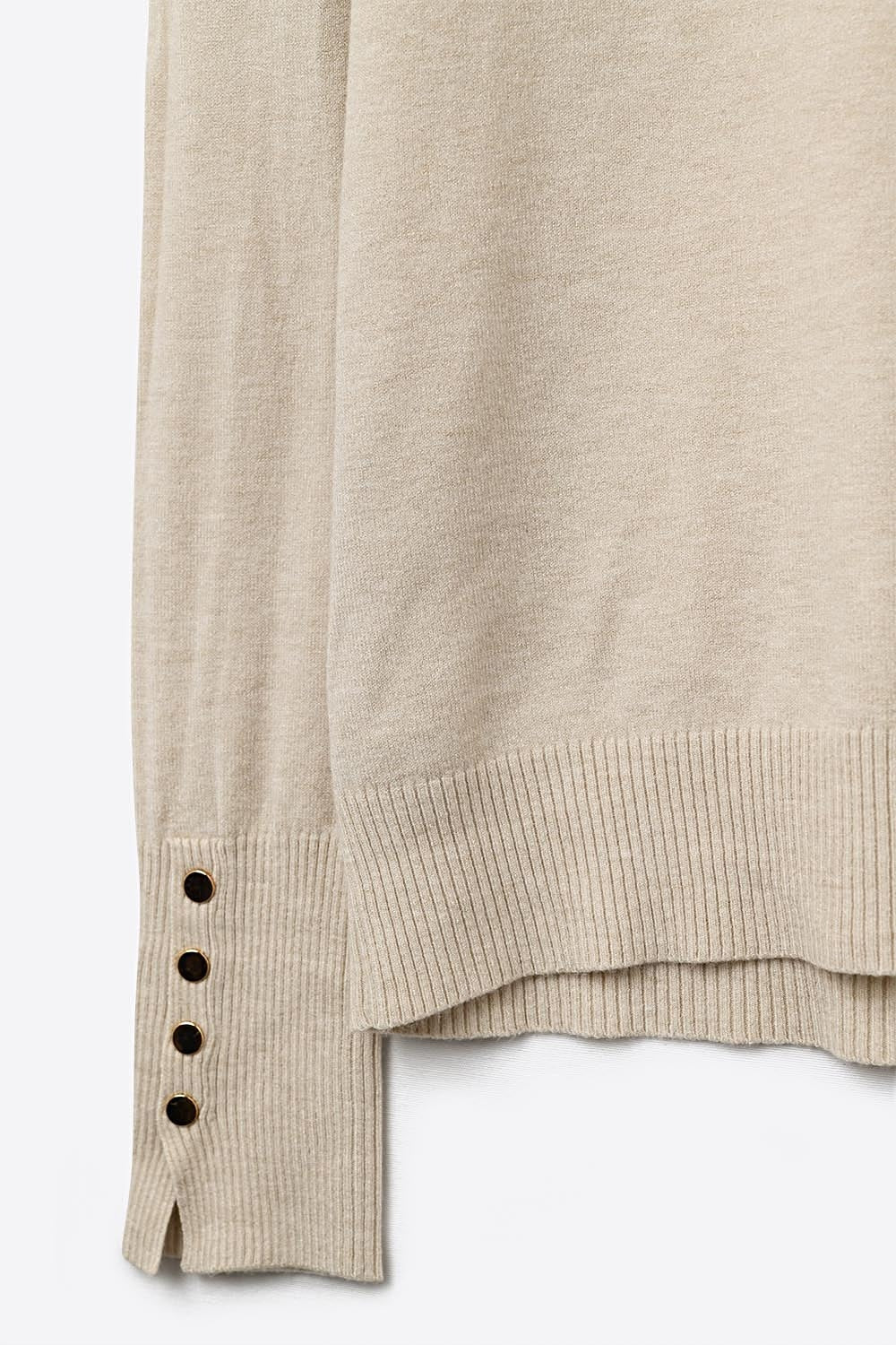 beige turtleneck sweater with gold buttons on the cuff