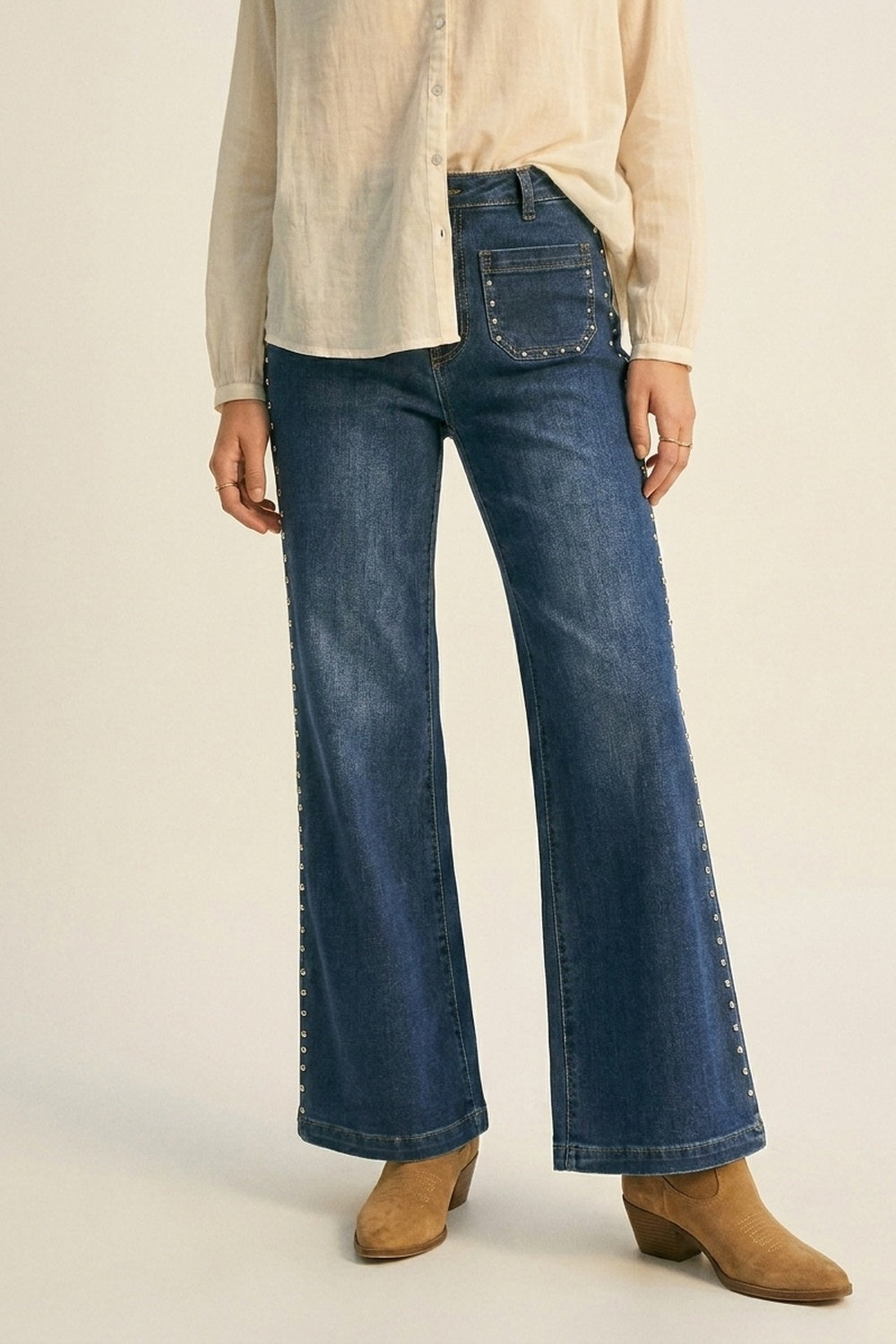 Jean évasé en denim bleu délavé avec clous latéraux