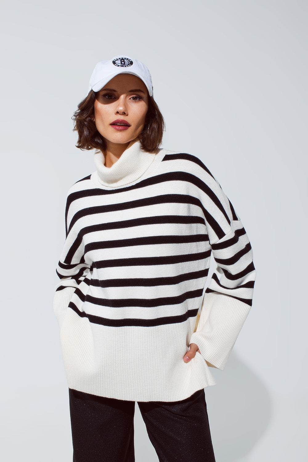 White oversized trutleneck sweater with black stripes and splits on the side