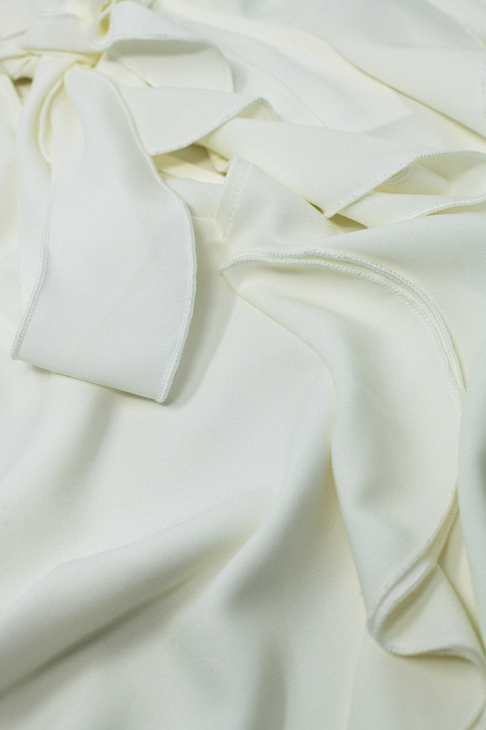 Sleeveless White Top with Ruffled Details and High Neck