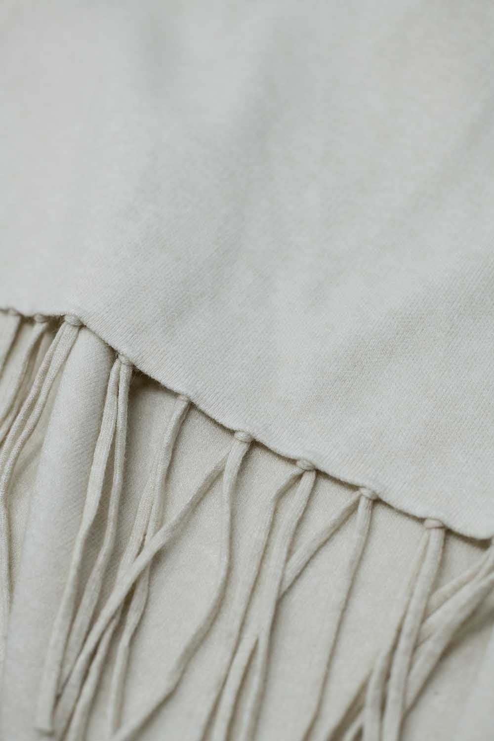 Soft knitted poncho in beige with fringes