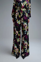 Calça fluída com estampado floral em tecido acetinado e bolsos laterais.