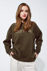 Khaki color hoodie with embroidered Cest La Vie text
