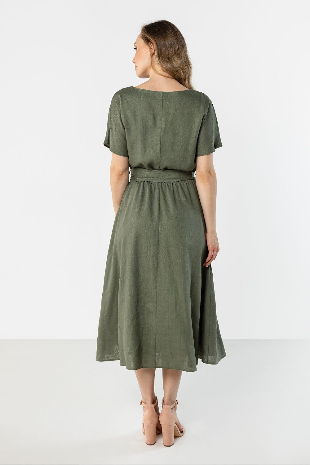 Back view of a green midi flared bottom dress by Awama with short sleeves and an elastic waist