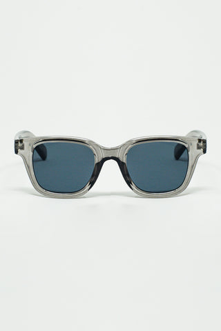 Lunettes de soleil rondes rétro avec verres noirs fumés et monture grise transparente