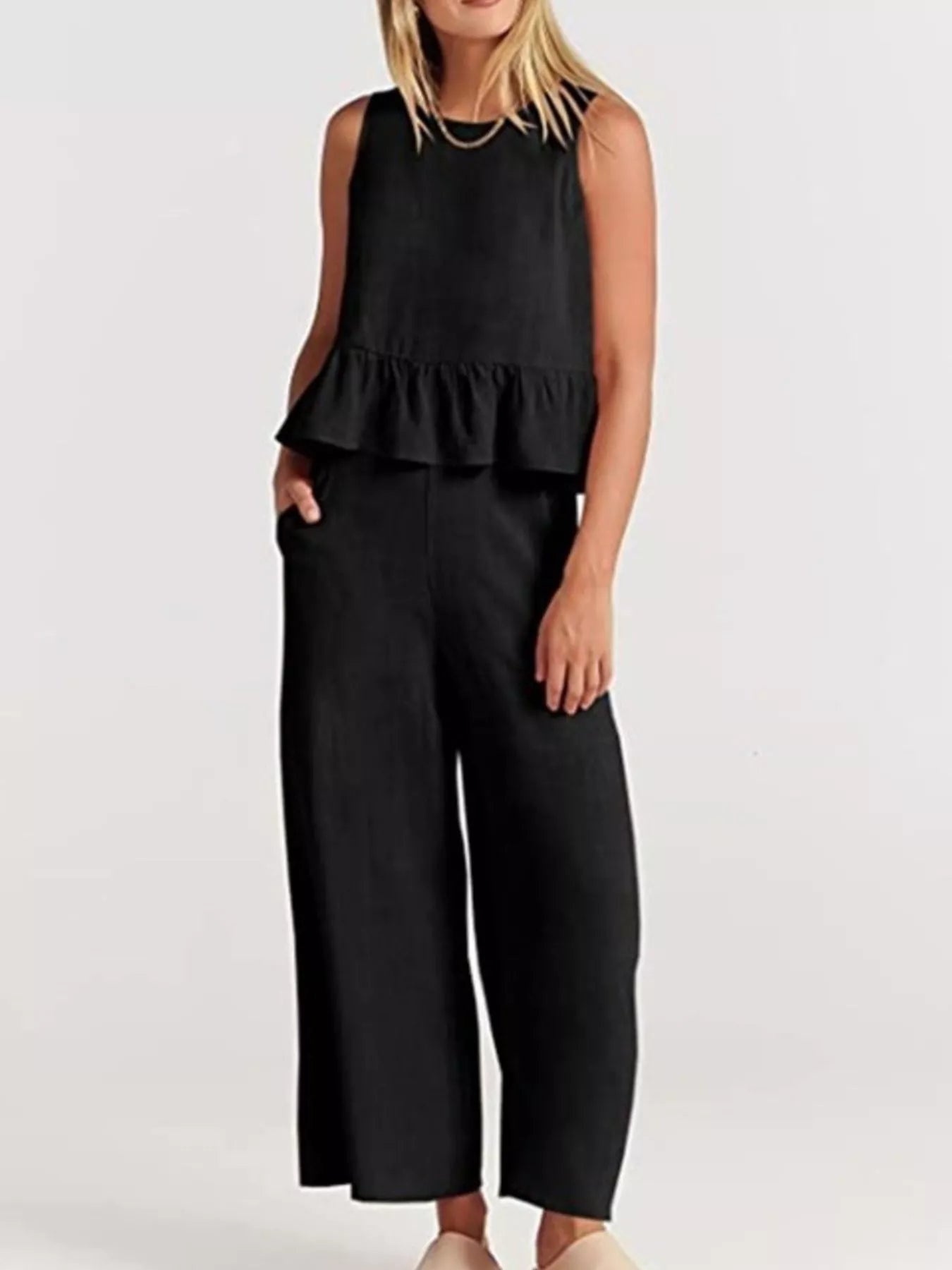 Trendsi set plus size featuring a black sleeveless top with peplum detail and matching wide-leg trousers