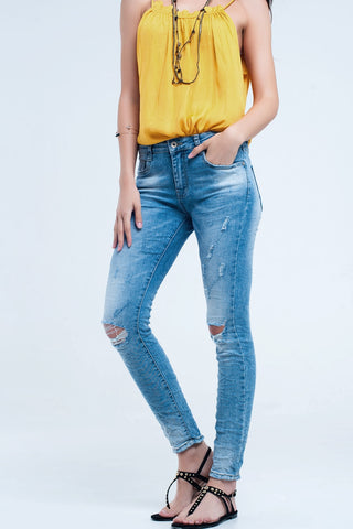 Jeans skinny com lavagem média e rasgos no joelho
