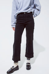 Jean droit noir avec jambes de pantalon pliées